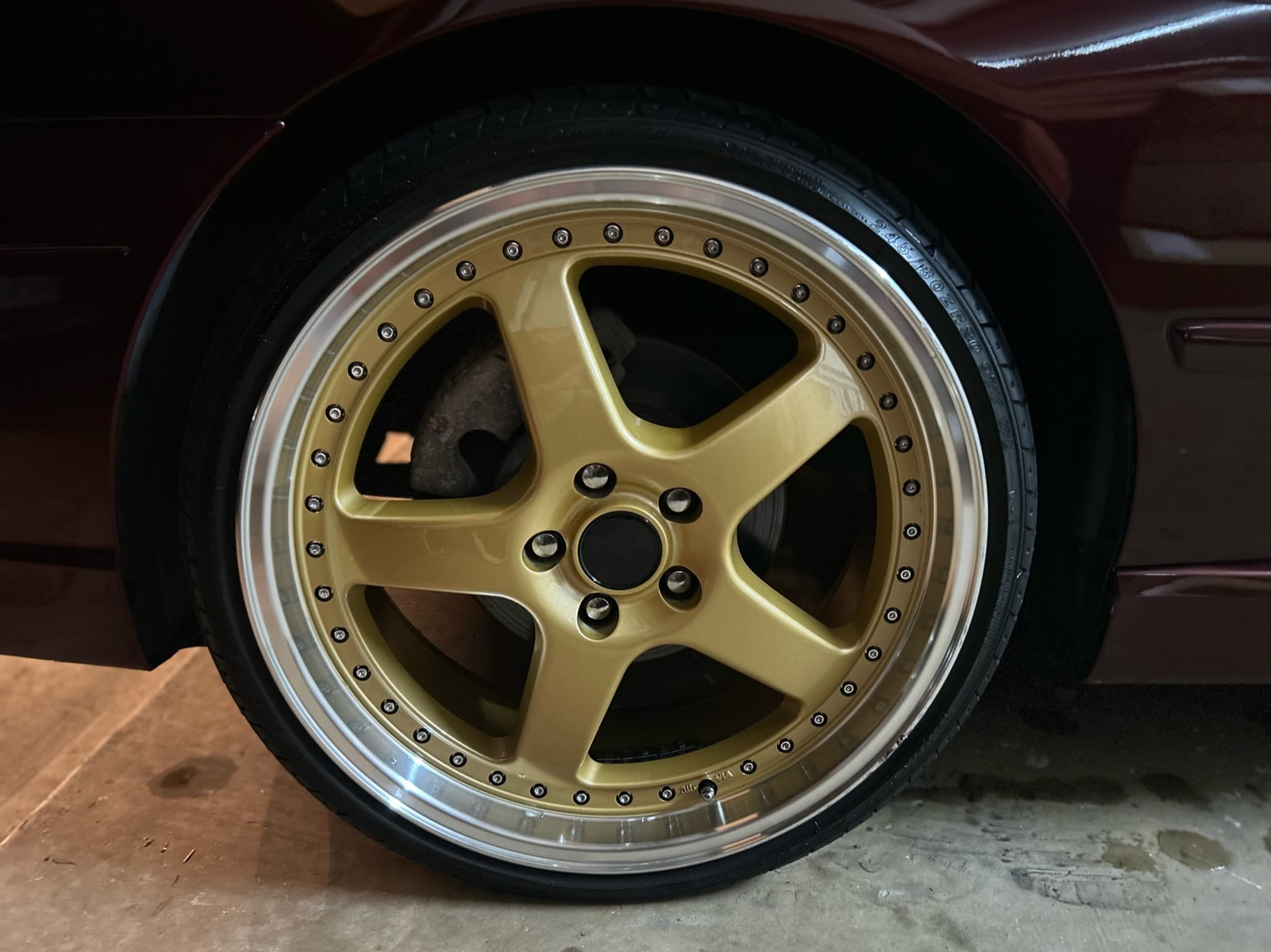 Gold 5-spoke alloy wheel cleaned and dressed on restored car